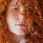 Donna che indossa una ragazza dai capelli rossi con colletto bianco