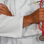 medico che tiene lo stetoscopio rosso