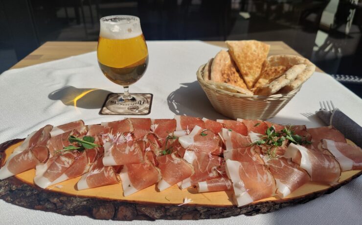 prosciutto sulla tavola con un bicchiere di birra