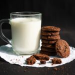 biscotti e latte in tazza di vetro trasparente con biscotti al cioccolato
