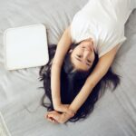 donna sdraiata sul letto ragazza benessere felicità