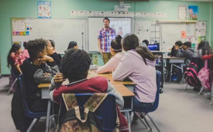 uomo e donna seduti su sedie in aula lezione scolastica attenzione apprendimento