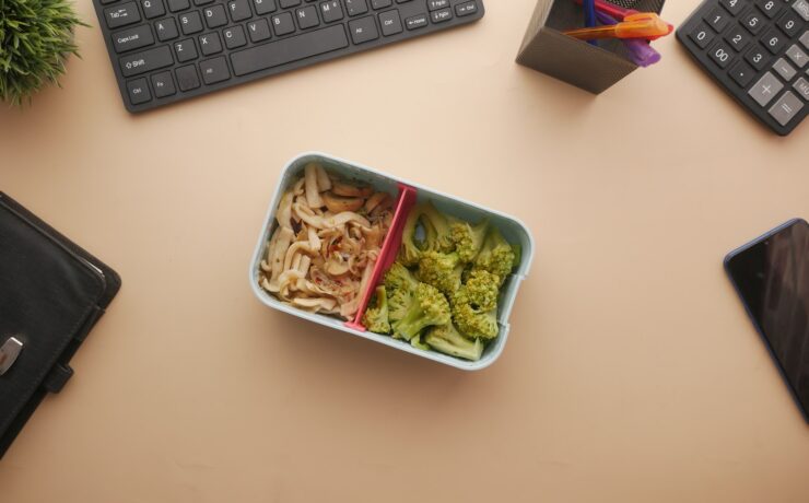 Vista dall'alto di un Lunchbox vegetariano e tastiere su un pranzo in ufficio Beige Desk scrivania