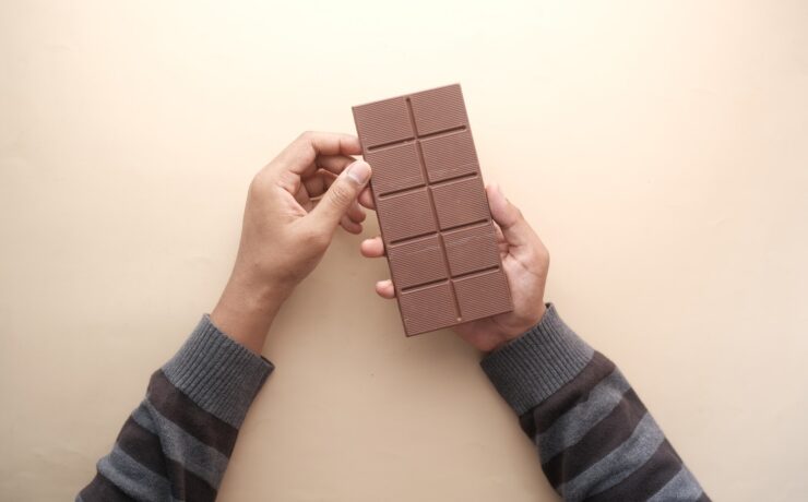 Man Holding Chocolate Bar in Hands