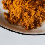 Spezie macinate in ciotola di metallo bianco curcuma
