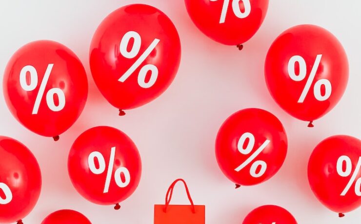 A Red Paper Bag in the Middle of Red Balloons With Percentage Symbols sales money