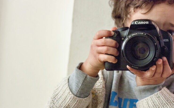 boy holding Canon DSLR camera