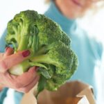foto della donna che tiene i broccoli cucina sacchetto