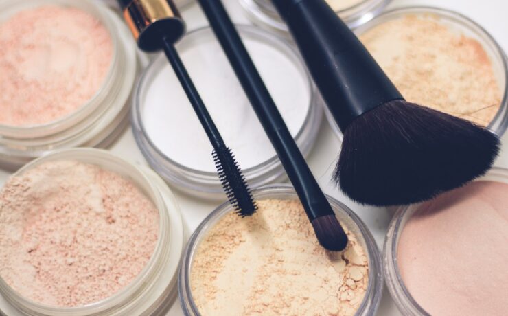 tre pennelli da trucco sopra a polveri compatte