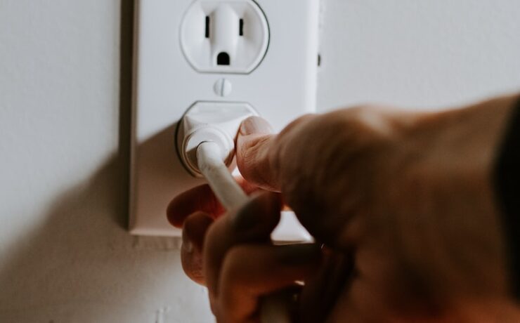 person holding white electric plug socket