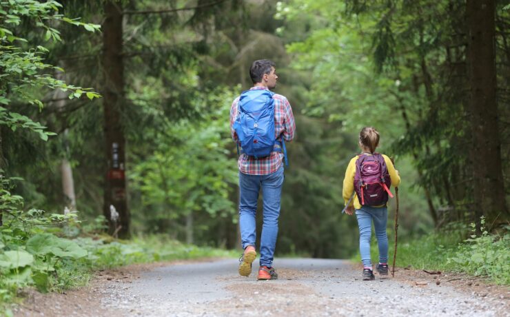 uomo in giacca blu e jeans blu che cammina su strada sterrata durante il giorno padre figlio