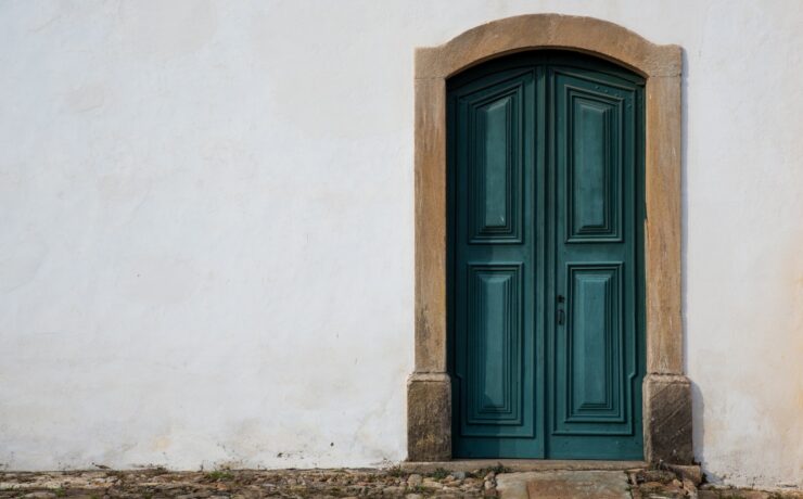 porta in stile barocco blu su un muro bianco