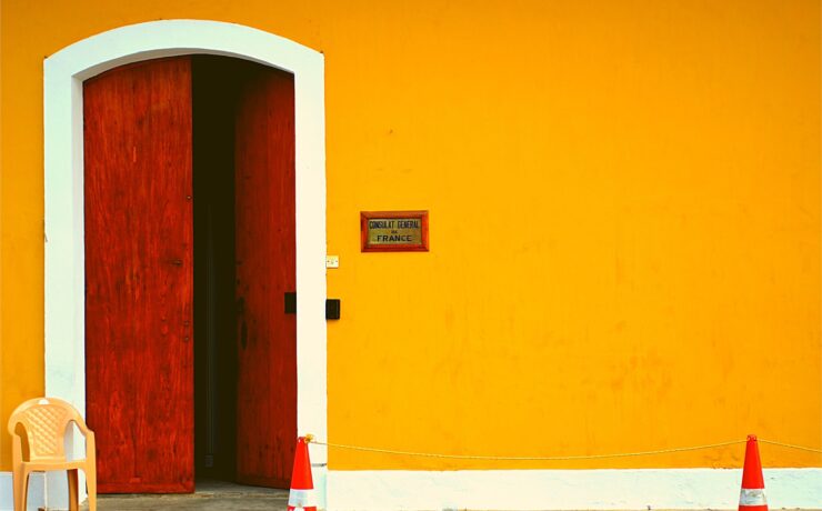 facciata giallo brillante e una semplice porta di legno marrone