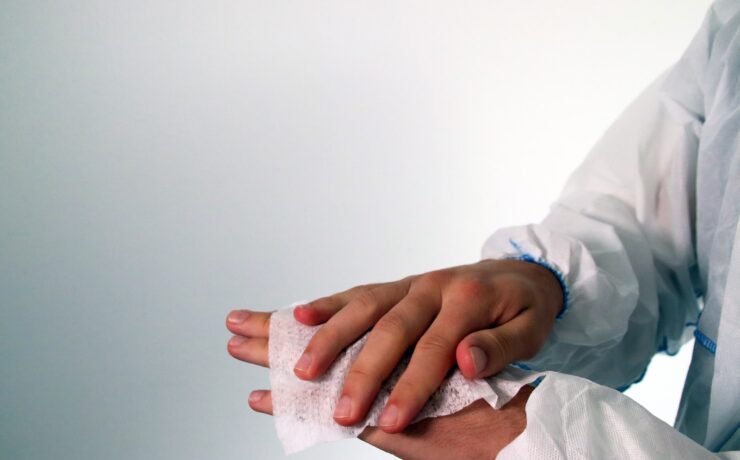 person in white long sleeve shirt holding white tissue paper sanitizing wipe