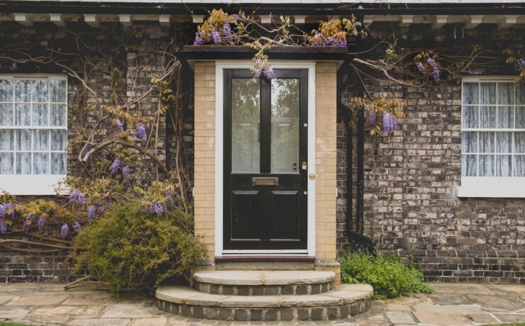 Facciata di una casa con porta in legno e parti in vetro