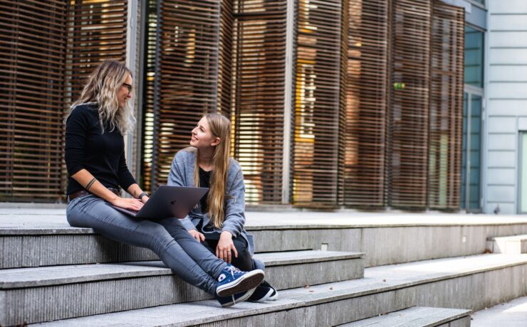 Due donne che parlano sedute sulle scale