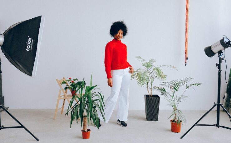 Mulher negra sorridente fazendo uma sessão de fotos com plantas