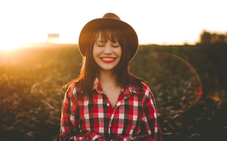 fotografia da hora dourada de uma mulher com camisa xadrez vermelha e branca