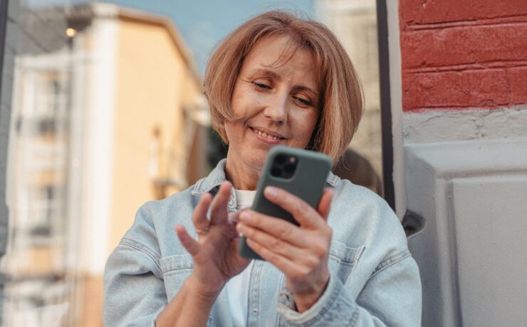 Donna che sorride mentre guarda il cellulare
