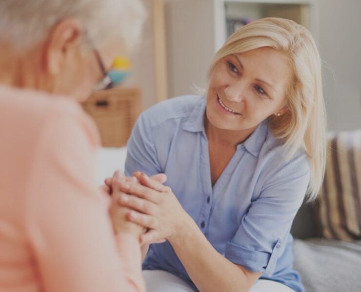 woman holding hands and smiling to other