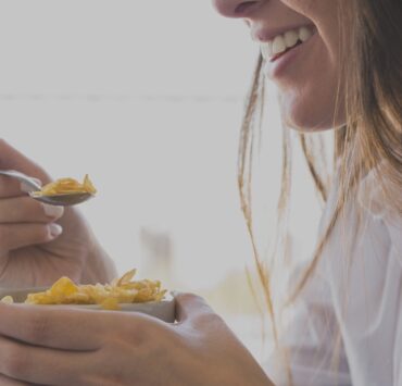 woman eating oaks breakfast while smiling