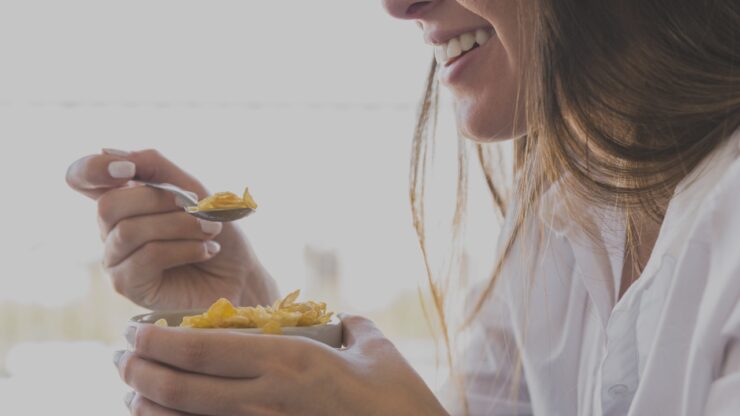 woman eating oaks breakfast while smiling