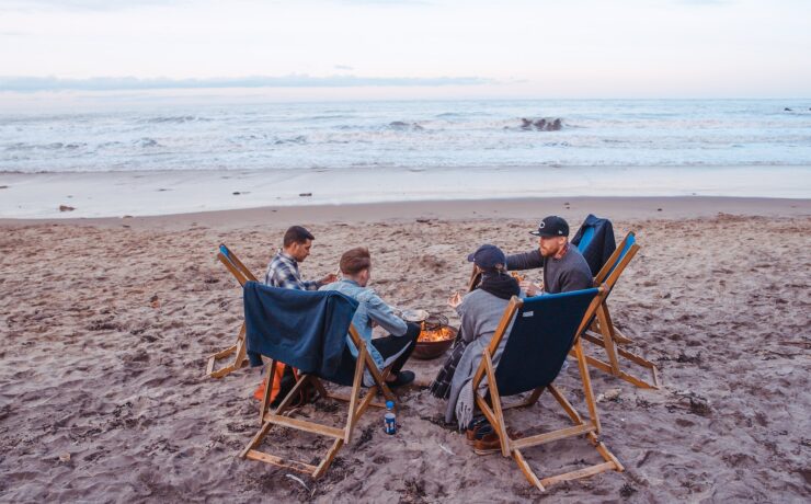 quattro amici sulla spiaggia che parlano e stanno insieme