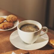 una tazza di caffè, biscotti, un bicchiere d'acqua