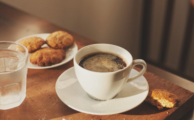 una tazza di caffè, biscotti, un bicchiere d'acqua