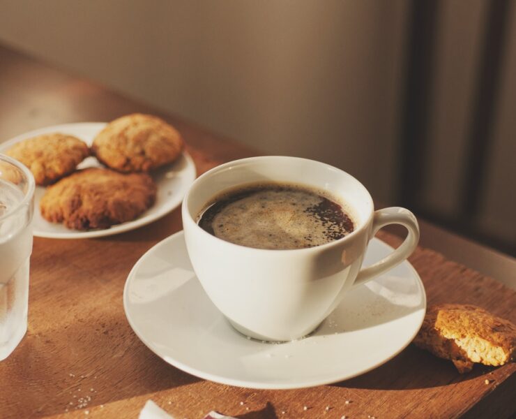 una tazza di caffè, biscotti, un bicchiere d'acqua