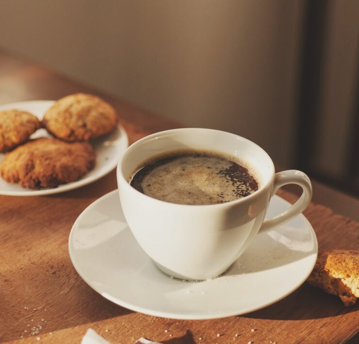 una tazza di caffè, biscotti, un bicchiere d'acqua