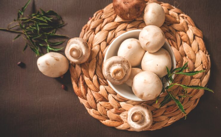 vários champignons de Paris em um pote sobre um suporte de palha