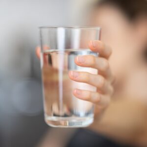 Persona che tiene un bicchiere d'acqua in mano