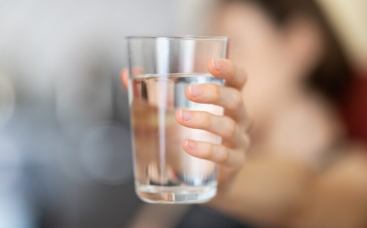 Persona che tiene un bicchiere d'acqua in mano