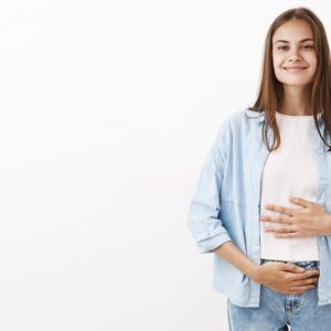 Donna che sorride con lo stomaco che sta bene dopo la digestione