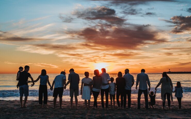 persone insieme sulla spiaggia al tramonto