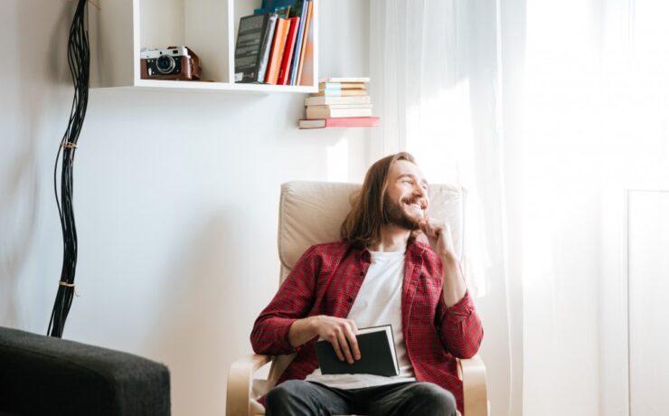 bearded man with a book smiling