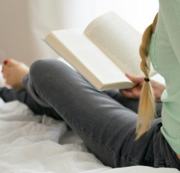 Woman Reading Book on Bed