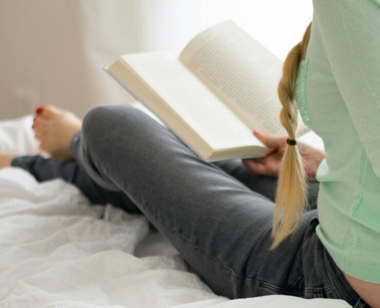 Woman Reading Book on Bed