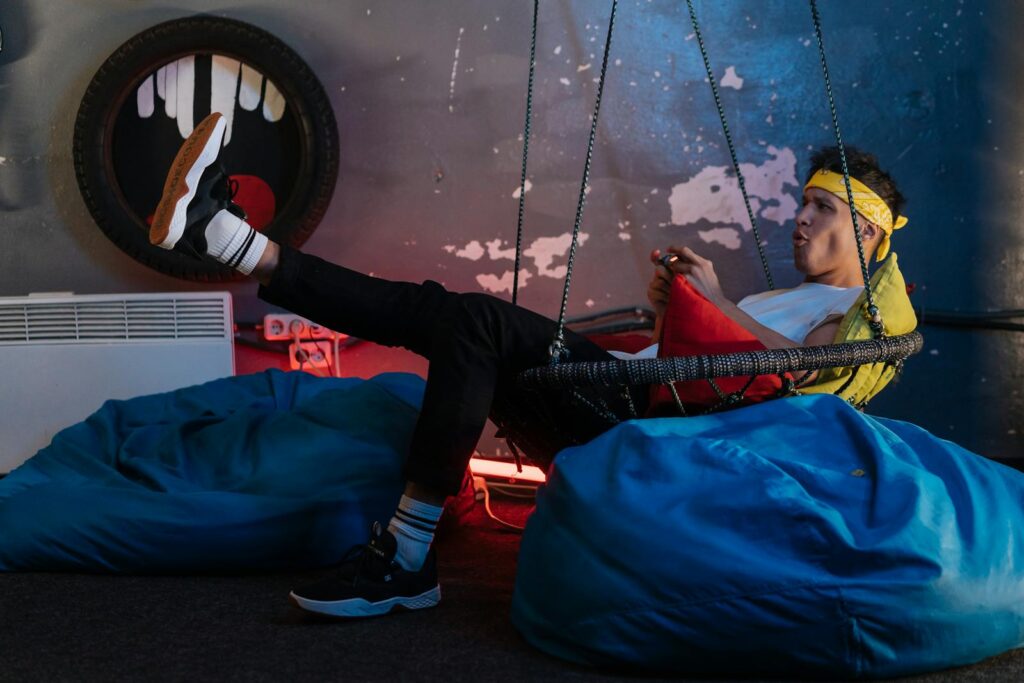 Man playing Games while sitting on a Hanging Chair