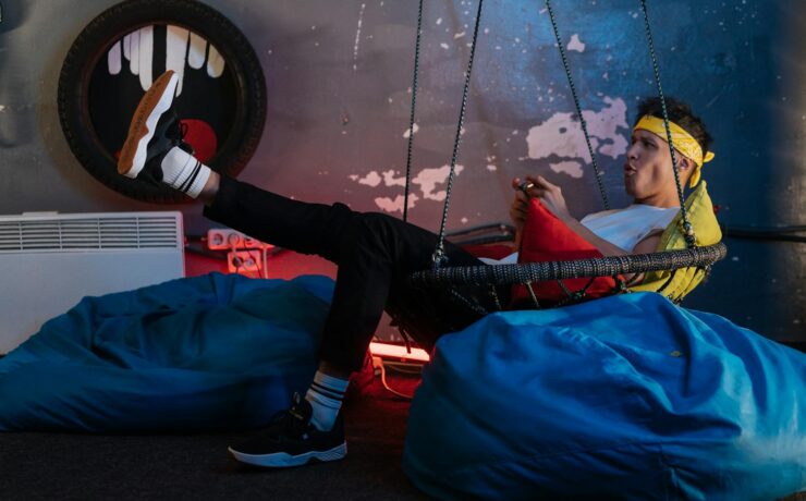 Man playing Games while sitting on a Hanging Chair