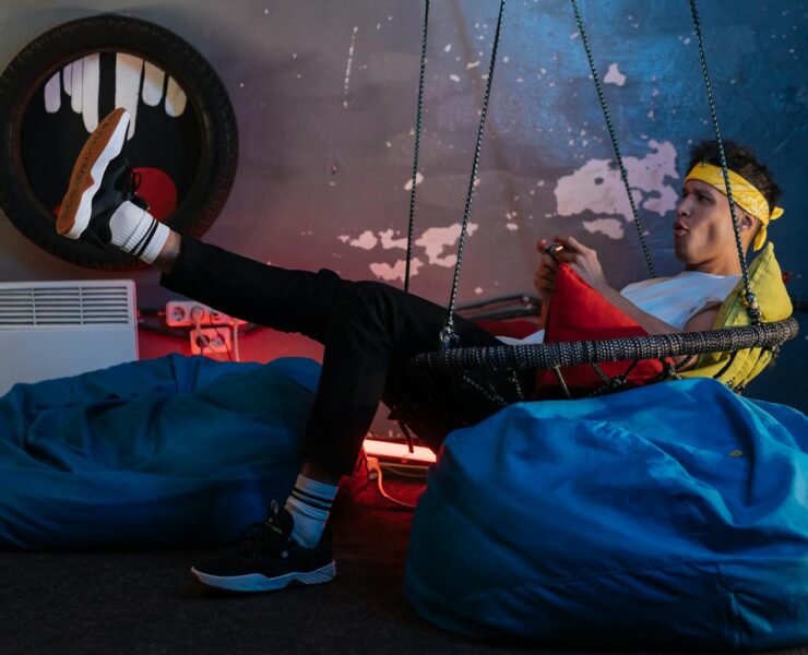 Man playing Games while sitting on a Hanging Chair