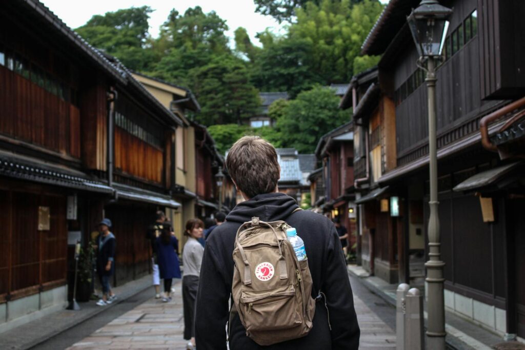 Tourist explores a charming traditional alley in Japan, capturing cultural essence. Kanazawa