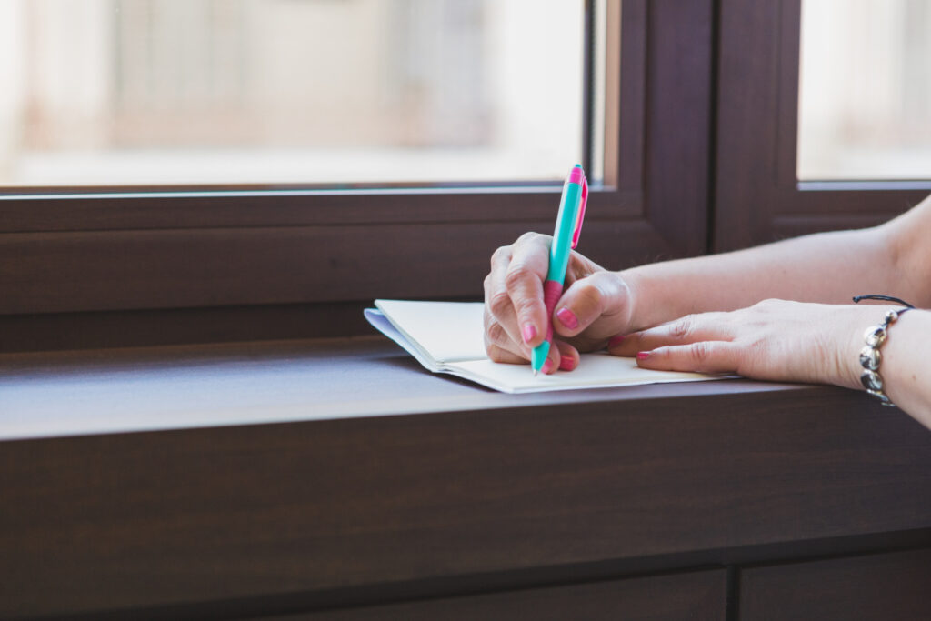 woman writing on a bloc notes