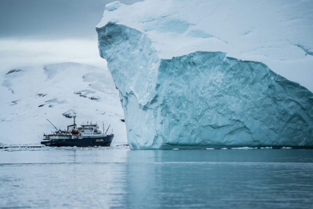 boat beside iceberg, greenland