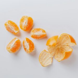 Top view of peeled and segmented mandarin on a white background, highlighting freshness and citrus appeal.