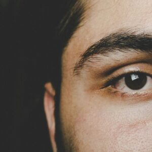 Detailed close-up of a man's eye highlighting natural eyebrow and skin texture.
