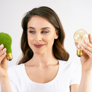 woman holding two light bulbs on of them is green