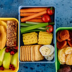 Vibrant assortment of sandwiches, fruits, and veggies in lunchboxes. Perfect for healthy meal prep inspiration.