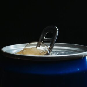 Detailed close-up of an open soda can with bubbles rising in a dark setting